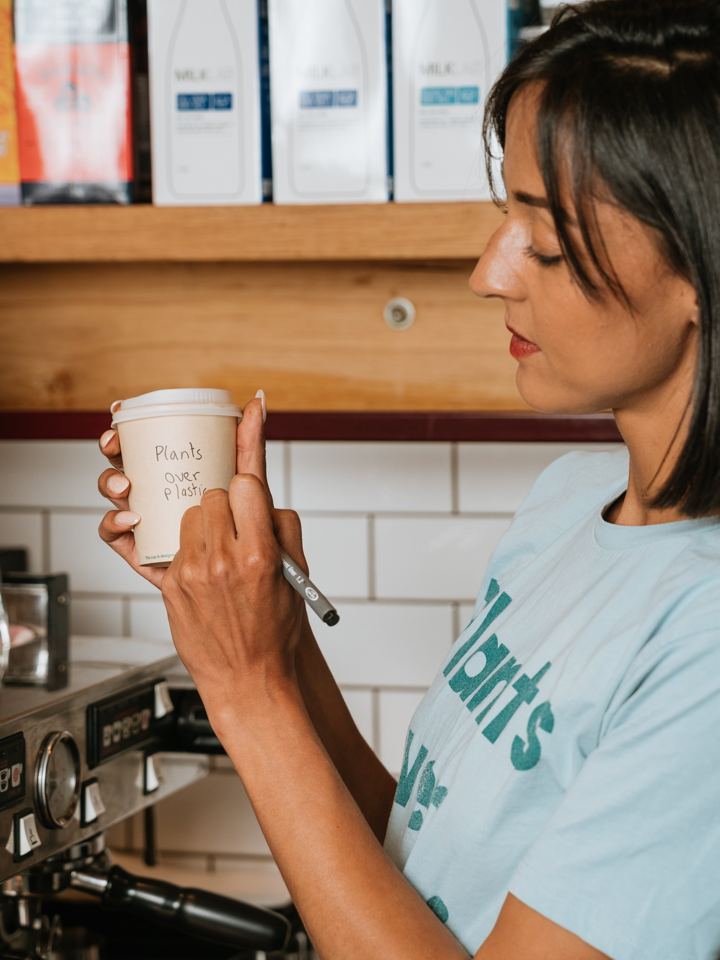 Barista with home compostable cups in a cafe