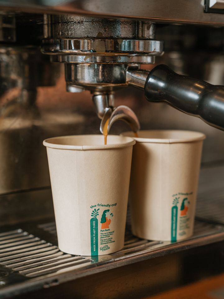 Espresso pouring into home compostable cups